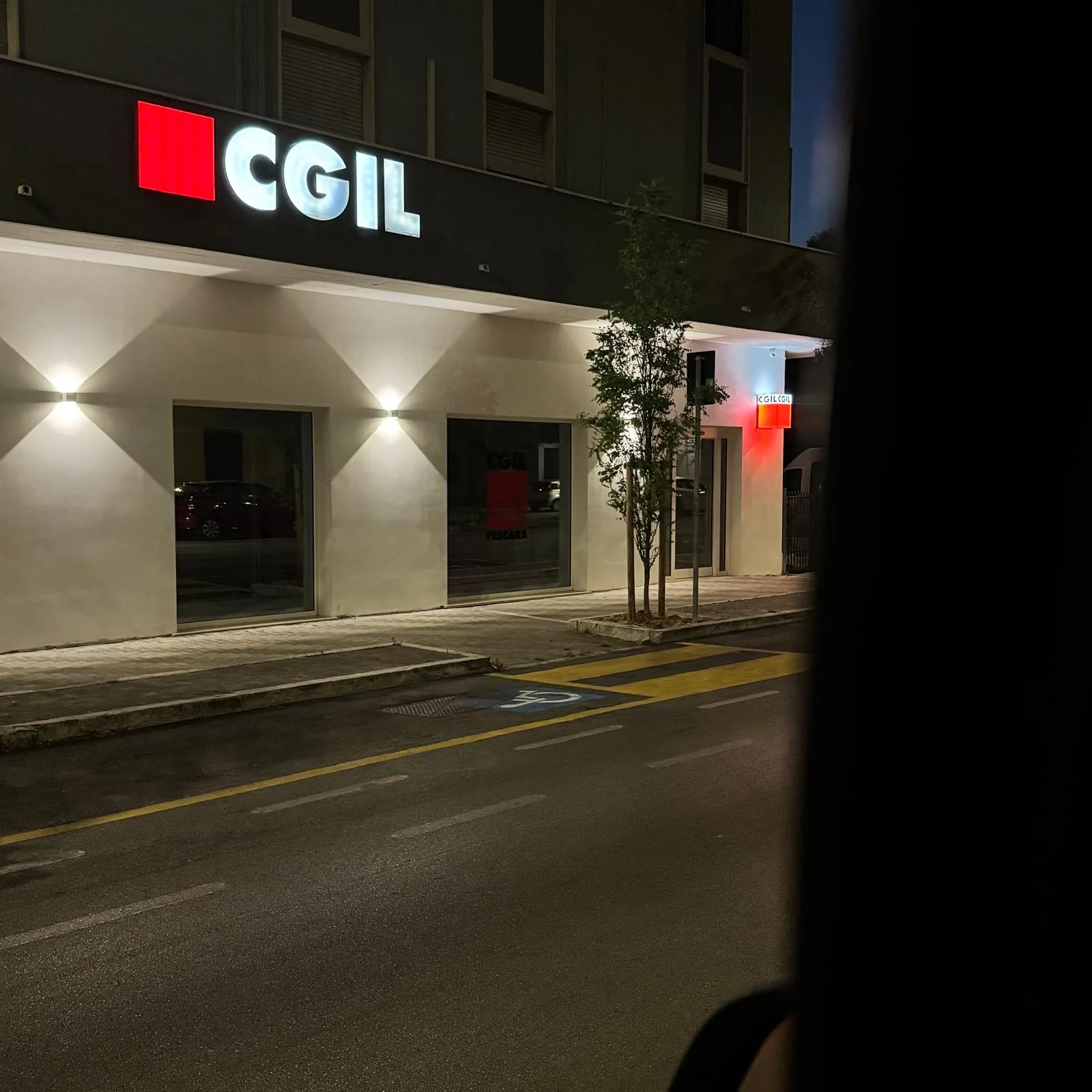Insegna luminosa CGIL su una facciata