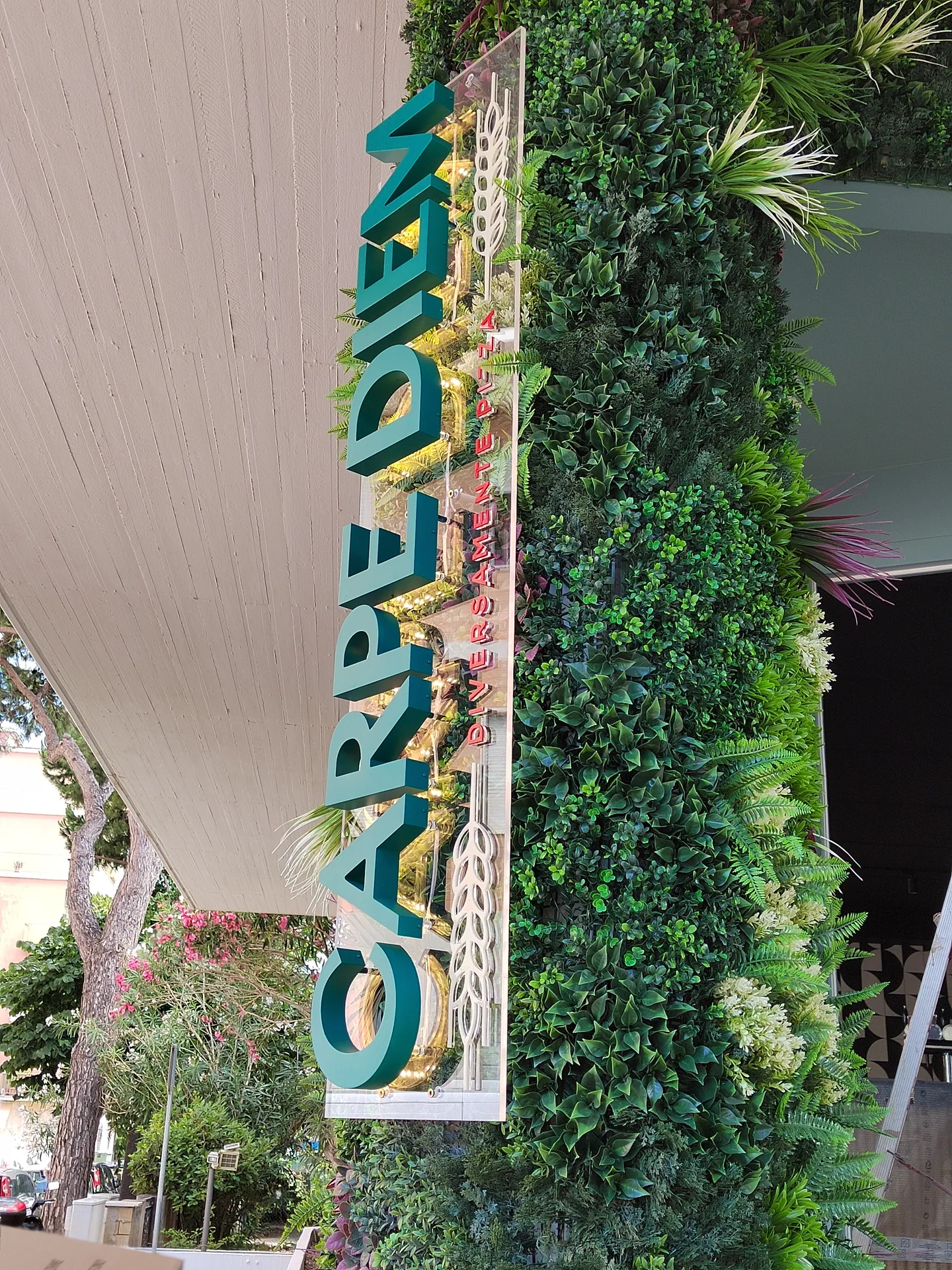 Insegna Garden con lettere scatolate su parete verde