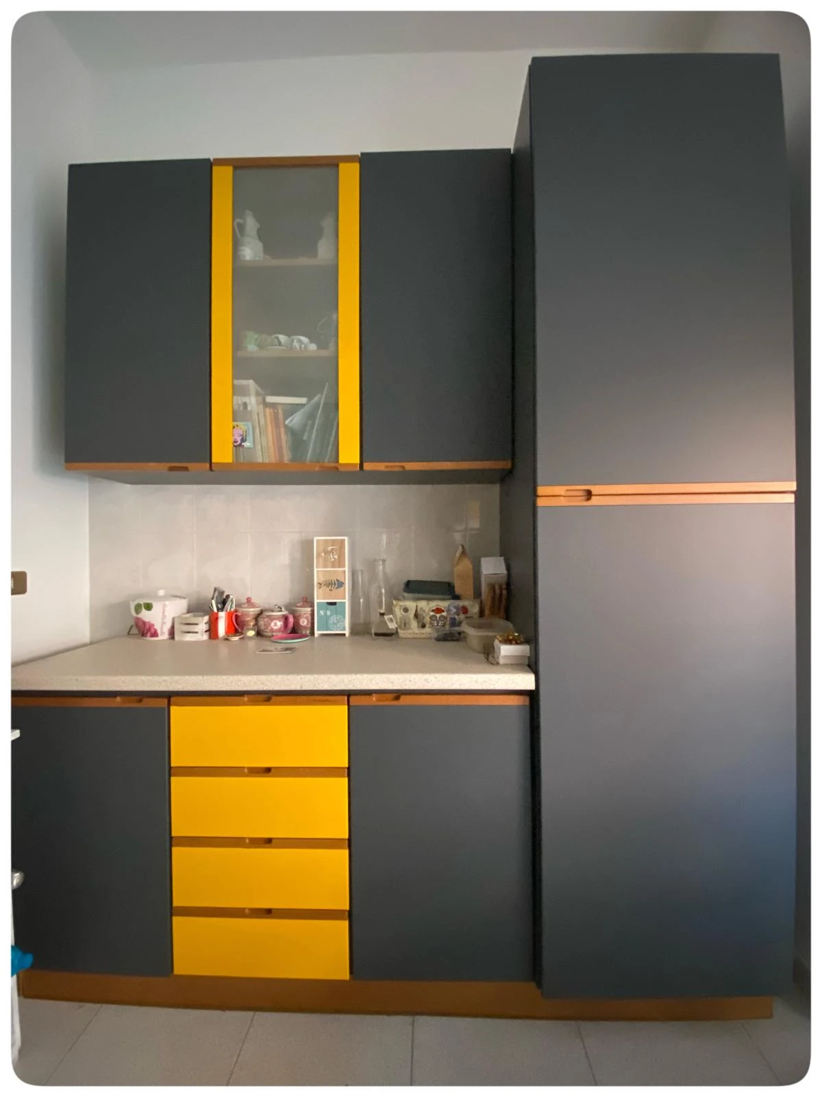 Cucina rinnovata con wrapping grigio, giallo e rame
